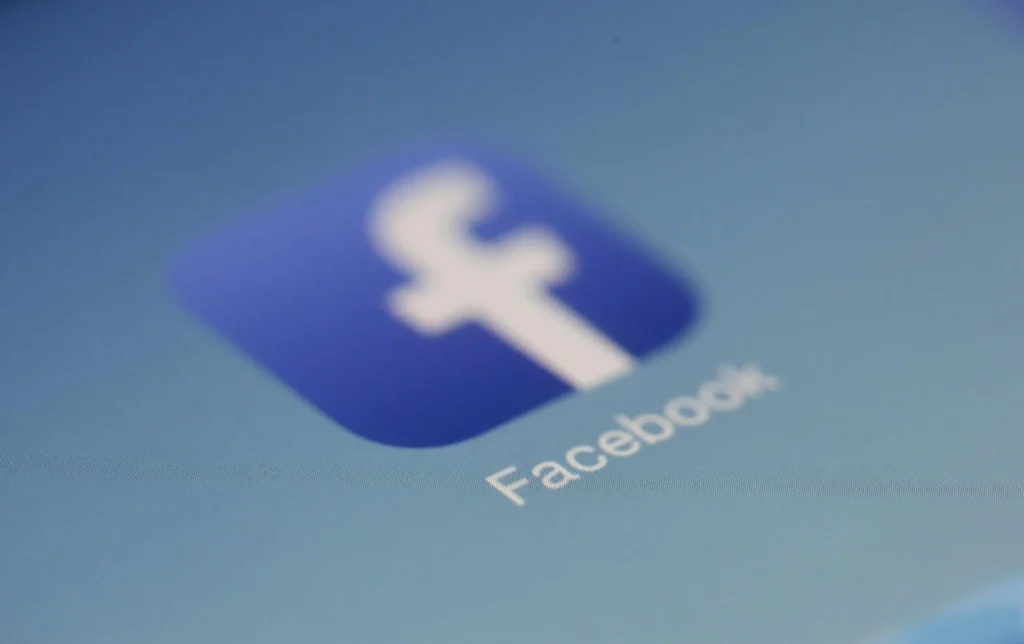 Ícone do Facebook com fundo azul e logotipo branco em uma tela digital.
